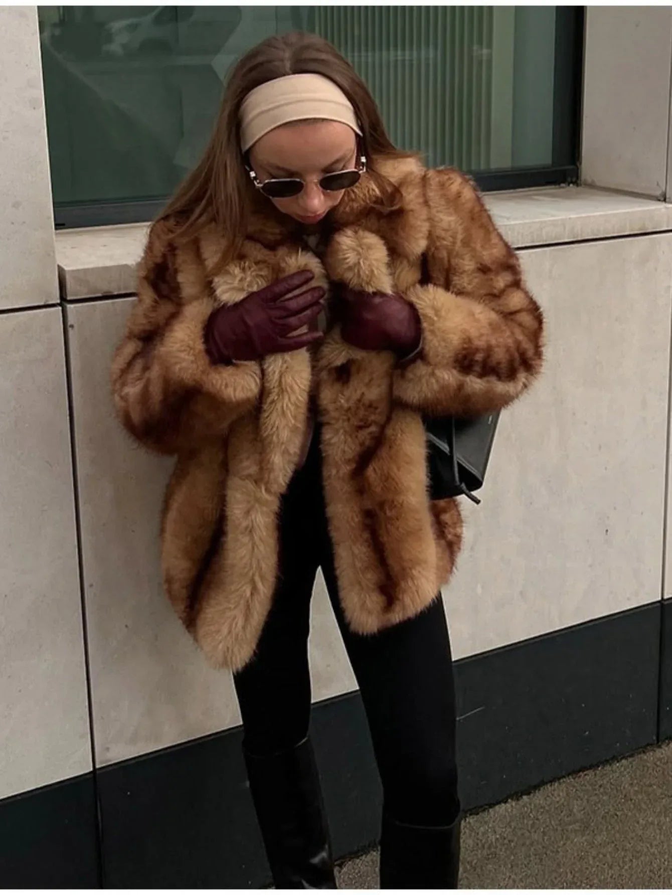 stylish woman adjusting her faux fur coat outdoors