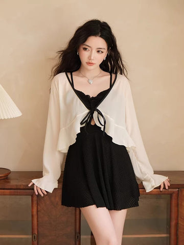 Woman wearing a black one-piece swimsuit with a white sheer cover-up.
