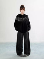Woman wearing a grey Fair Isle knit hoodie with snowflake pattern and zipper