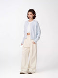 Side view of a woman in a light blue cropped knit cardigan.