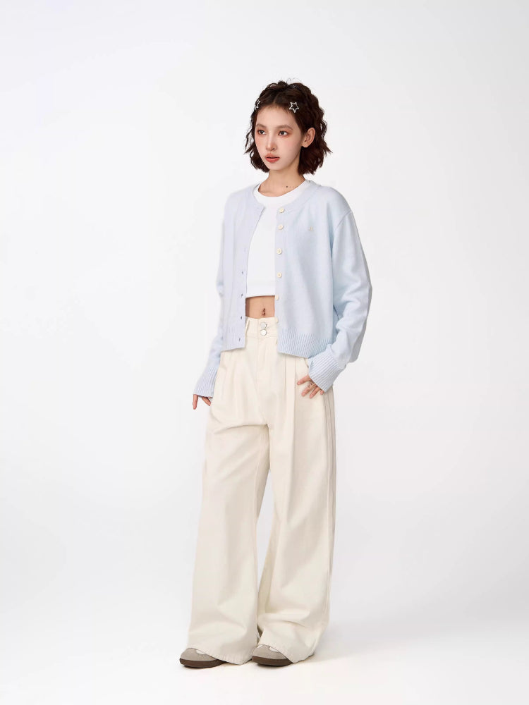 Side view of a woman in a light blue cropped knit cardigan.