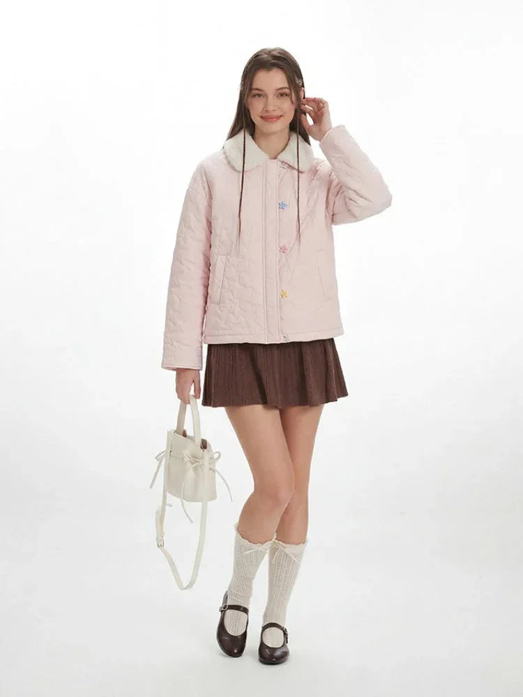 Front view of a woman in a pink quilted jacket, brown skirt, and white socks.