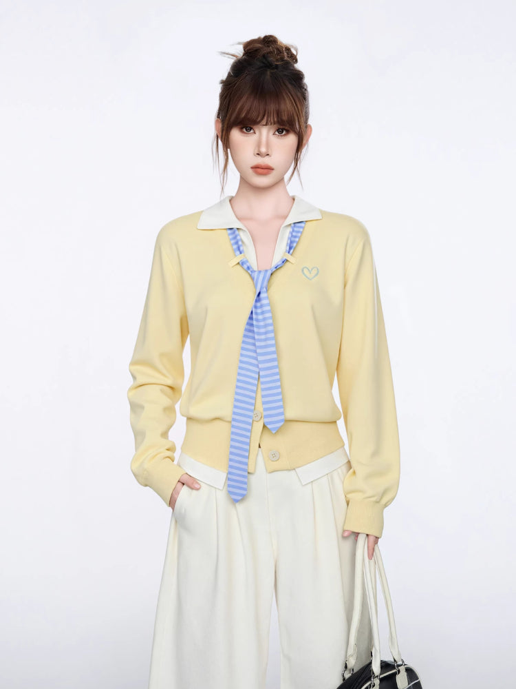 Woman wearing a pastel yellow knit cardigan with a white collar and blue striped tie
