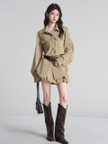 Woman standing, showcasing the khaki camp collar shirt dress, layered hem, and accessories including a belt and knee-high boots.