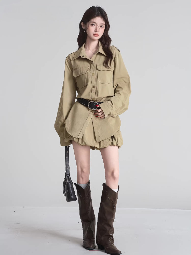 Woman standing, showcasing the khaki camp collar shirt dress, layered hem, and accessories including a belt and knee-high boots.