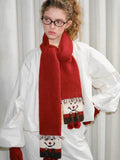 Close-up of the snowman motif on a red knit scarf