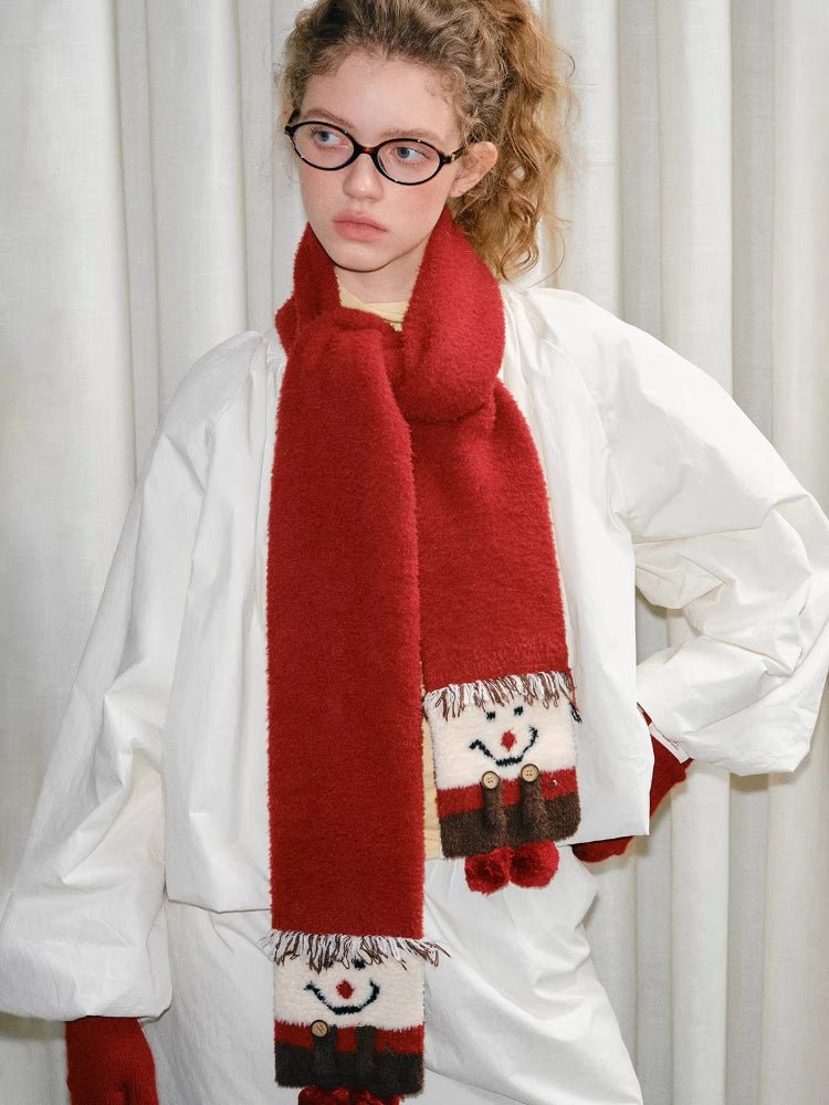 Close-up of the snowman motif on a red knit scarf