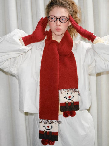 Woman wearing a festive red knit scarf with a cartoon snowman design