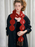 Woman wearing a red novelty knit scarf with linked circles