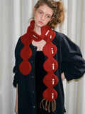 Detail of the brown tassel fringe on the red knit scarf