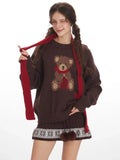 Model styling the brown knit sweater with a festive scarf.