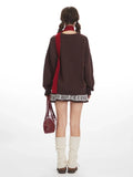 Back view of a woman in a brown oversized knit sweater with a holiday motif.