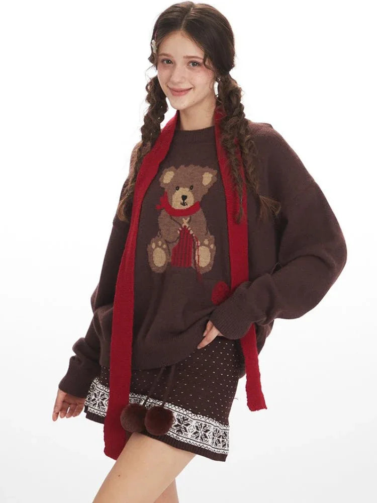 Close-up of the teddy bear graphic on the brown knit sweater.