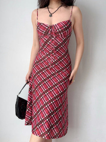 woman wearing a red and pink plaid mesh midi dress with spaghetti straps and a tie front detail