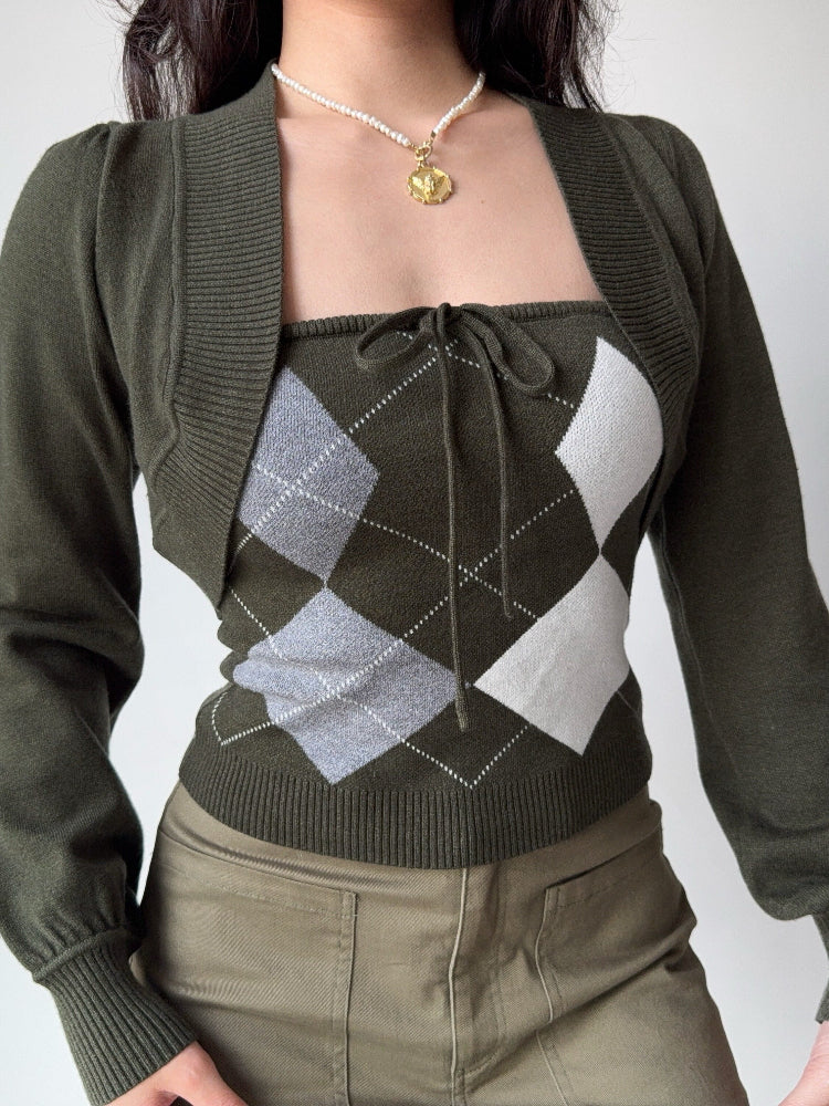 Detail of the puff sleeves and ribbed cuffs on the dark green knit bolero.