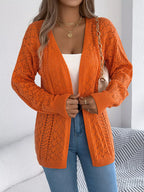 Front view of a woman wearing an orange open-knit cardigan, showcasing the open front and knit pattern.