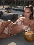 Woman wearing a beige embroidered bikini with floral details