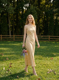 Woman walking in a grassy field wearing a sleeveless yellow jacquard floral midi dress.