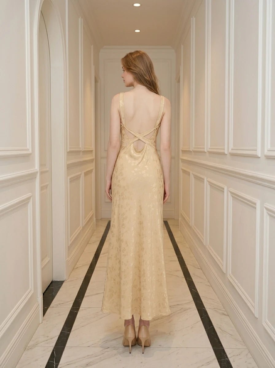 Woman wearing a sleeveless yellow jacquard floral midi dress with a round neckline and criss-cross back straps.