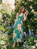 Woman wearing a green midi dress with a floral print, standing in a garden with roses.