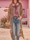 Woman wearing a brown lace duster over a satin top and blue jeans