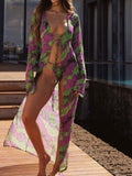Woman wearing a long, flowing tie-dye duster with green and purple abstract print.