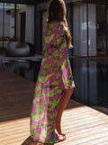 Back view of a woman in a long, sheer tie-dye duster with split sides.