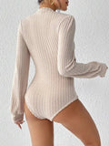 Close-up of the ribbed texture and puff sleeve detail on a cream bodysuit
