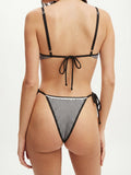Back view of a woman in a black and white gingham bikini set with adjustable straps and tie-side bottoms
