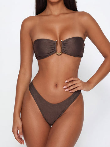 Model wearing a brown strapless bikini with gold hardware