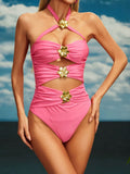 Pink one-piece swimsuit with gold floral accents and cut-out details
