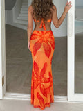 Front view of a woman in a vibrant orange and red floral print bikini set with a sarong