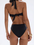 Back view of a woman wearing a black halter bikini with a tie closure