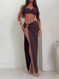 Woman wearing a brown bikini top and a brown high-slit maxi skirt with a starfish embellishment.