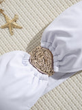 Close-up of the gold hardware detail on a white bikini top.