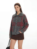 Side view of a woman in a plaid collared knit jacket and brown skirt.