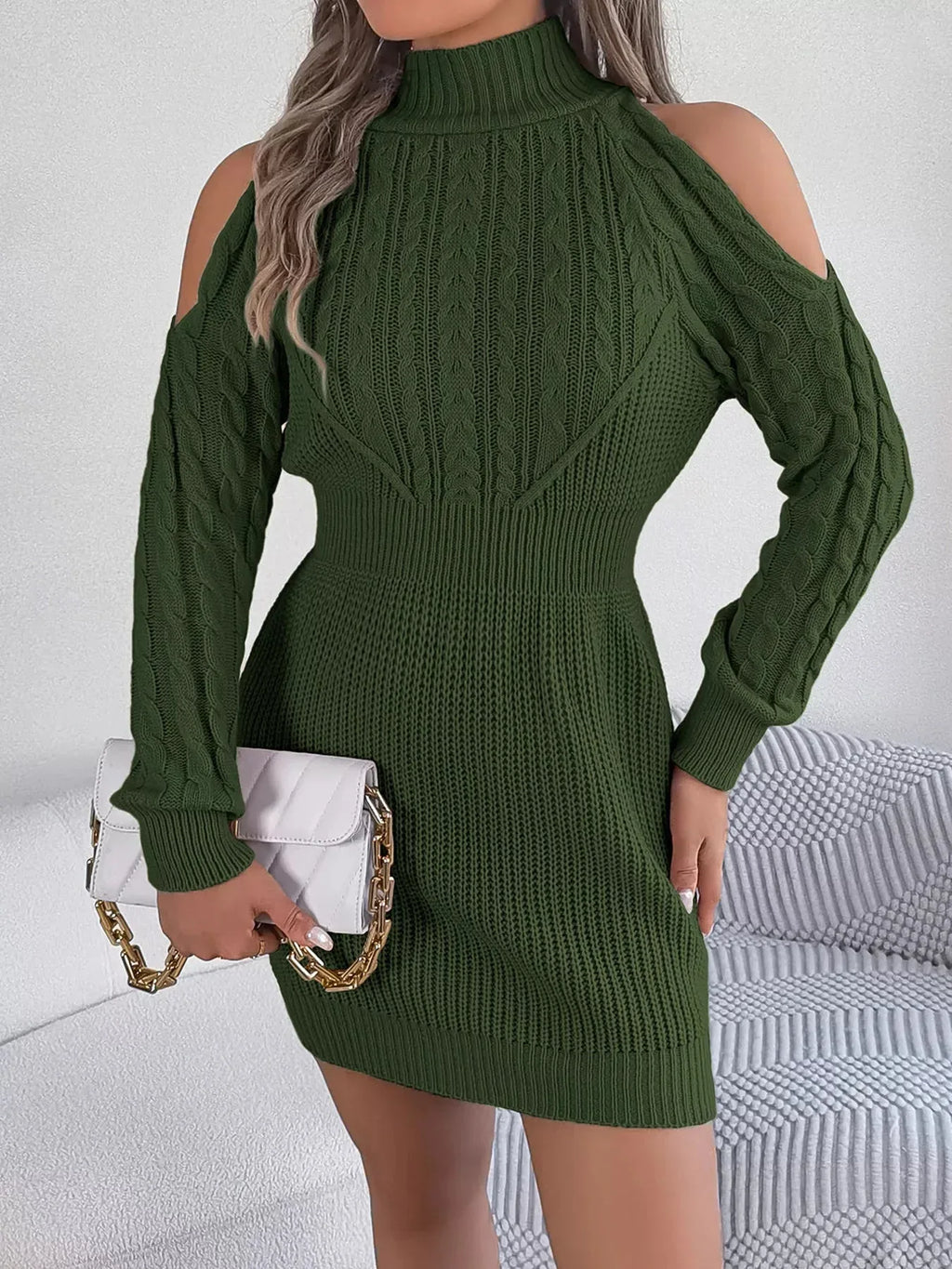 Close-up of a woman wearing a green cold shoulder knit dress with intricate cable knit details