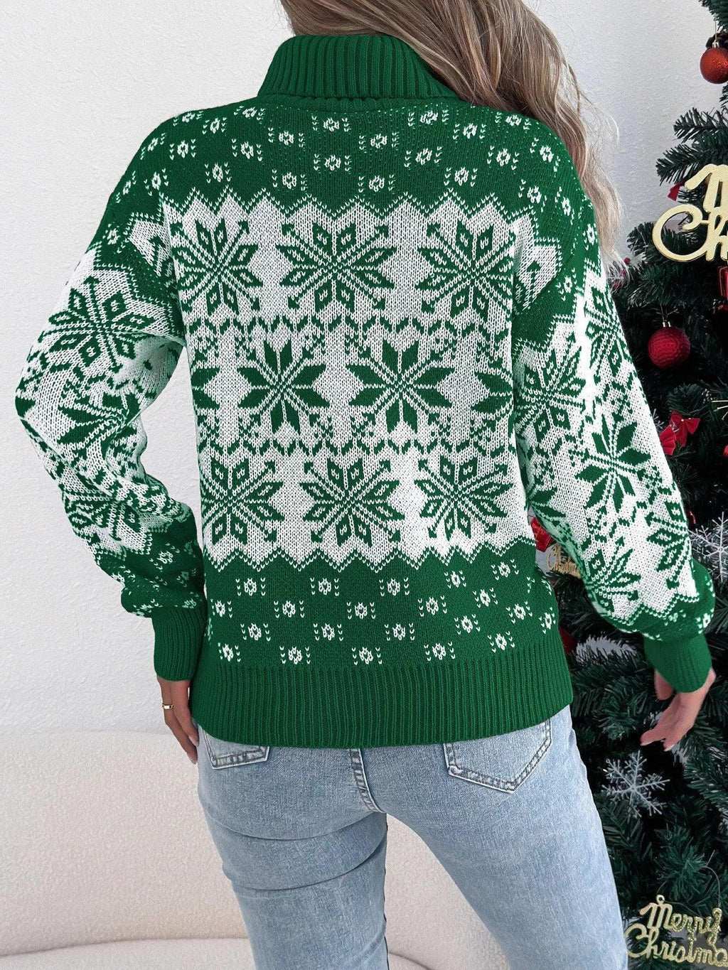 Woman wearing a green and white snowflake pattern turtleneck sweater, back view.