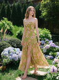 Woman wearing a green floral print strapless maxi dress standing in a garden