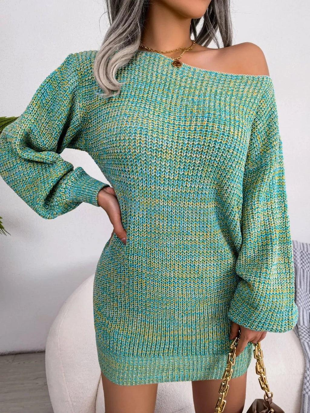 Woman wearing a green and yellow marl knit off-the-shoulder dress with long balloon sleeves.