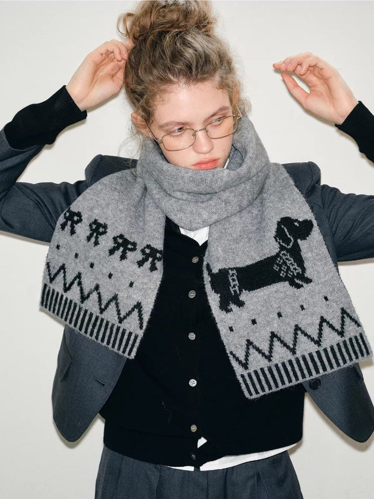 Woman wearing a grey knit scarf with a black dachshund graphic and geometric pattern
