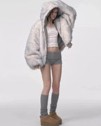 Woman in a grey bomber jacket with a voluminous faux fur hood