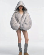 Woman wearing a grey bomber jacket with a large faux fur hood