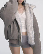 Close-up of a woman wearing a grey bomber jacket with white faux fur trim