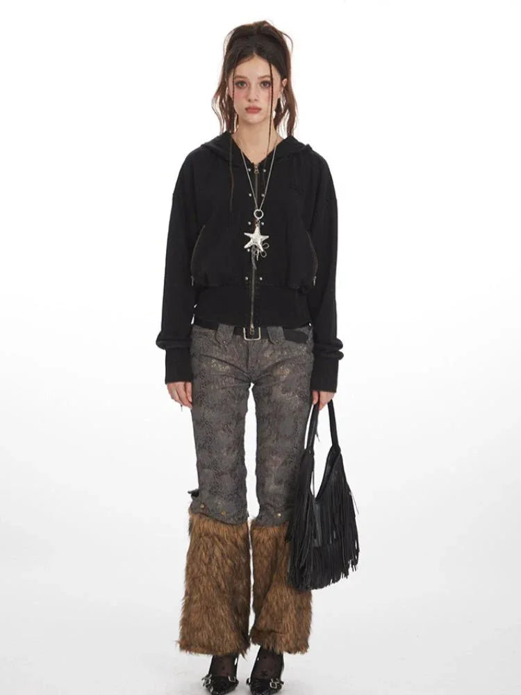 Woman wearing a black cropped hooded zip-up jacket, patterned pants, and furry leg warmers. Main image