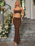 Woman wearing a brown halter neck crop top and a matching brown maxi skirt with a mermaid hemline.