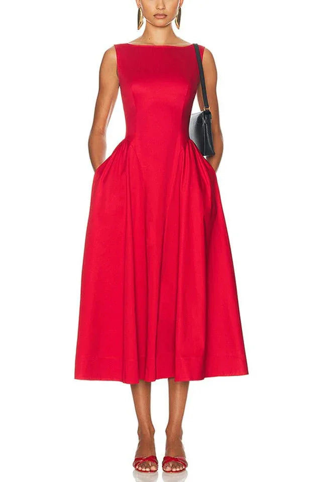 Woman wearing a sleeveless red midi dress with pockets and a boat neckline.