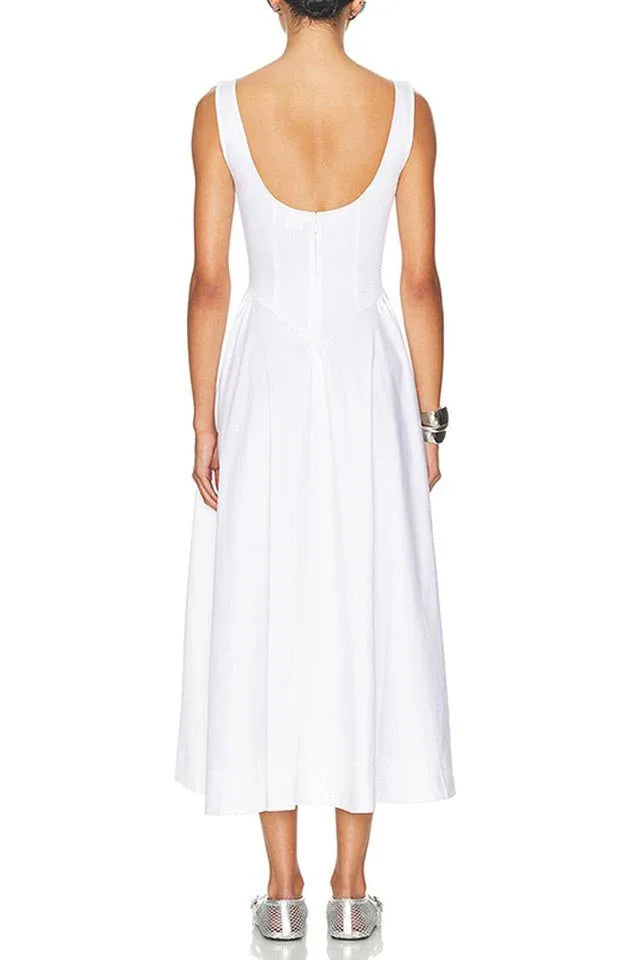 Back view of a woman in a sleeveless white midi dress with a scoop back.