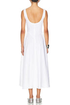 Back view of a woman in a sleeveless white midi dress with a scoop back.