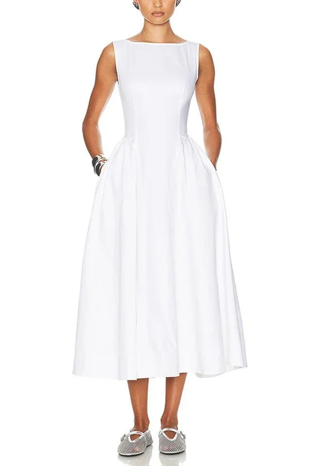 Woman wearing a sleeveless white midi dress with pockets and a boat neckline.